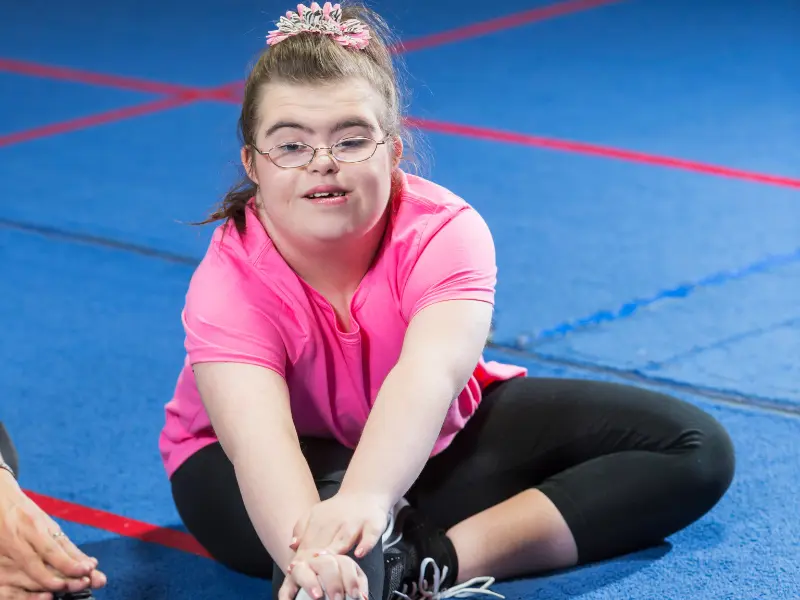 Disabled girl stretching in group fitness class
